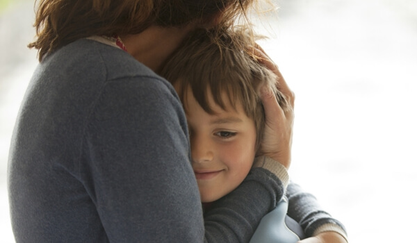 Niño feliz abrazado por su madre