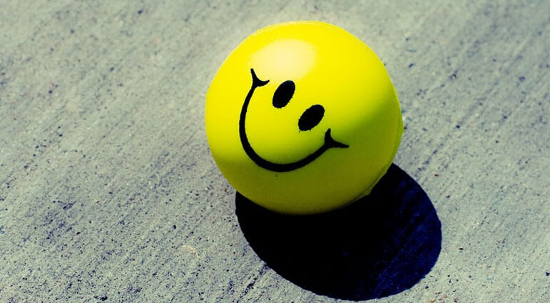 Pelota amarilla con una cara sonriendo