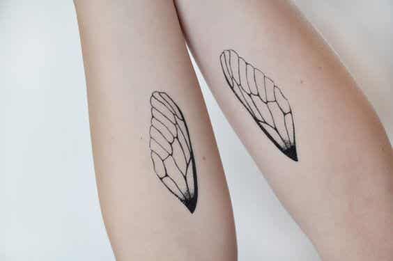 brazos con tatuajes de alas simbolizando el paso del tiempo