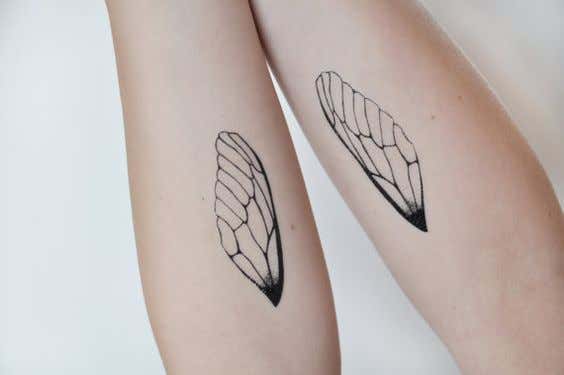 brazos con tatuajes de alas simbolizando el paso del tiempo