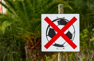 Cartel con pelota tachada para que los niños no jueguen a fútbol