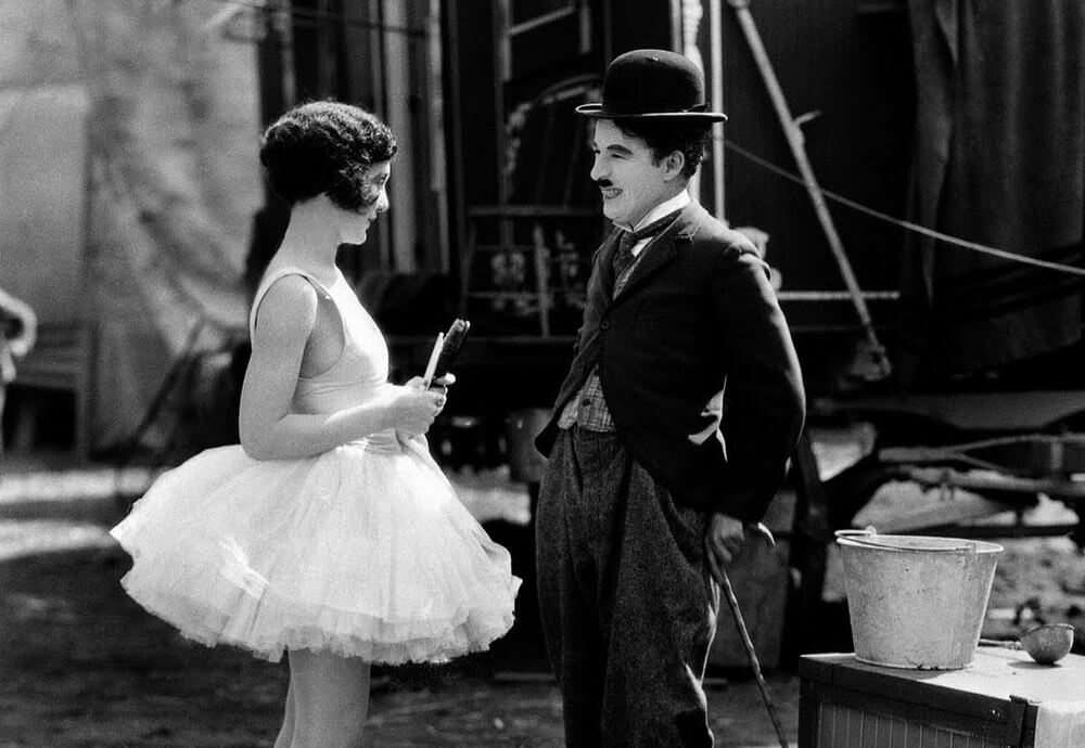 Charles Chaplin sonriendo con una actriz
