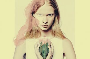 chica con flor entre las manos que piensa lo que haces