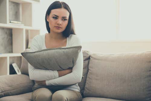 Chica sentada en un sofá pensando excusas para no ir al psicólogo