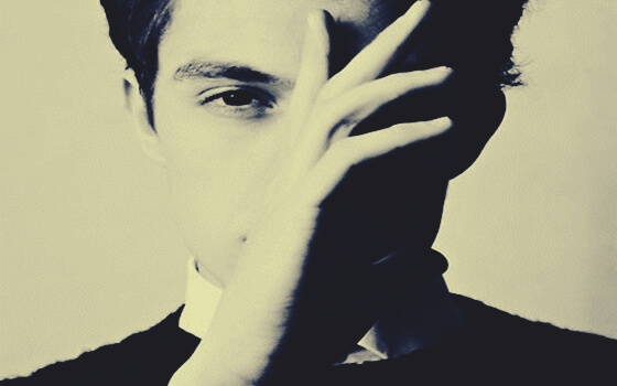 chico con la mano en el rostro que piensa lo que haces