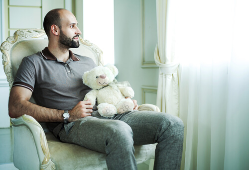 Hombre con síndrome de peter pan con peluche