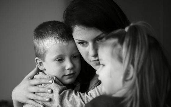 madre abrazada a sus hijos
