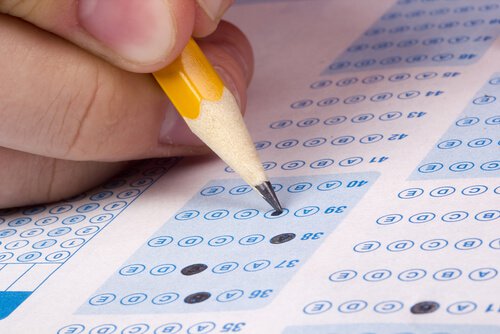 Mano con lápiz rellenando un examen