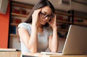 Mujer cansada leyendo en su ordenador un artículo sobre cuando necesitamos descansar