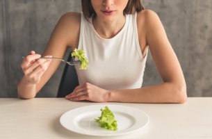 Mujer con ortorexia comiendo lechuga