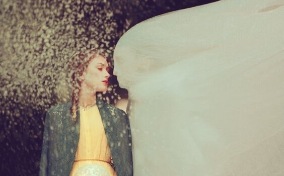 Mujer con hombre cubierto bajo un velo blanco