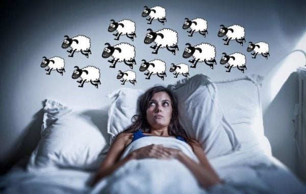 mujer con insomnio contando ovejas