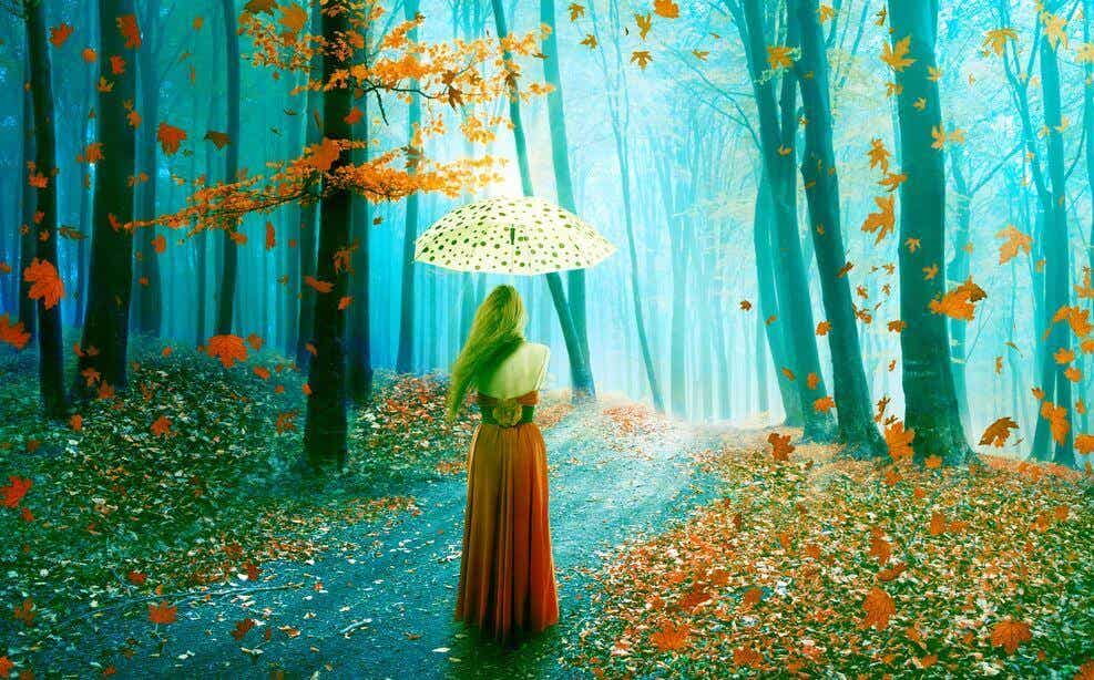 Mujer con paraguas paseando por el bosque pensando en el olvido