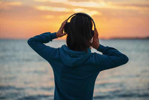 Mujer escuchando música mirando al mar