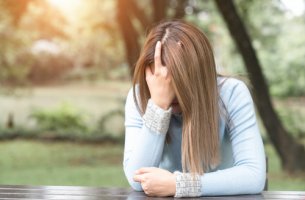 Mujer preocupada con la mano en la cabeza