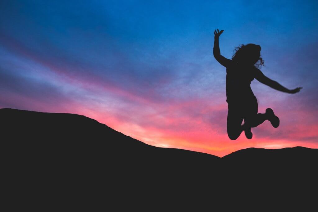 Mujer saltando al atardecer