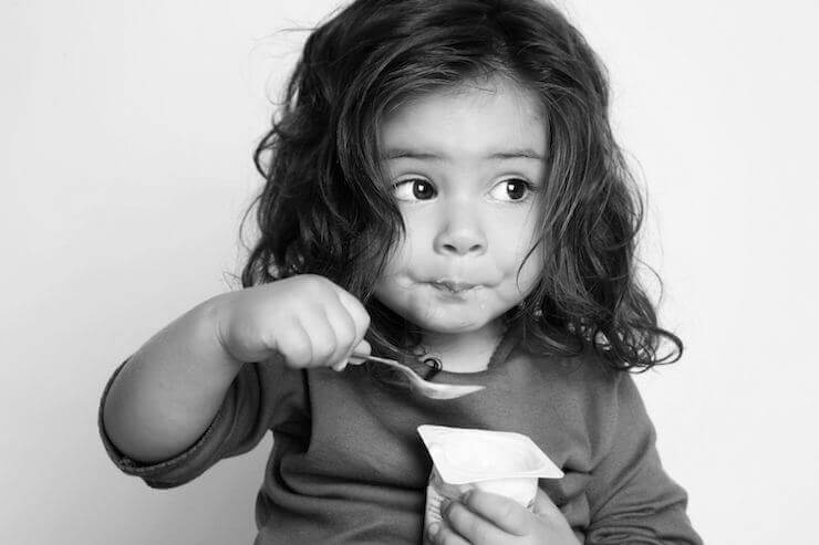 Niña comiendo yogur