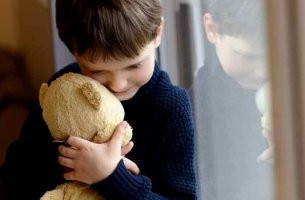 Niño abrazando a un oso sufriendo por vivir con una familia disfuncional