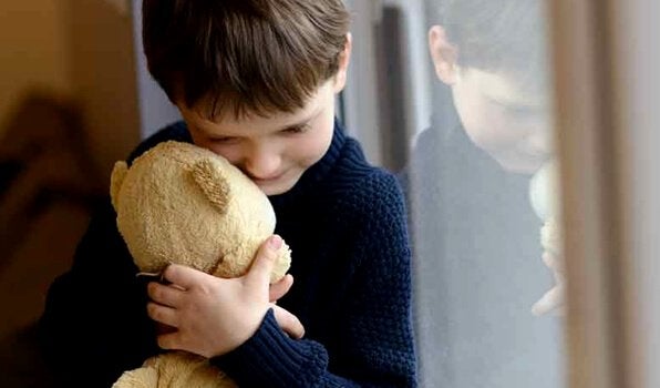 Niño abrazando a un oso sufriendo por vivir con una familia disfuncional