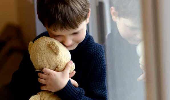 Niño abrazando a un oso sufriendo por vivir con una familia disfuncional