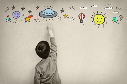 Niño pintando dibujos en la pared