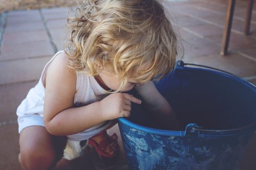 Niño zurdo buscando en un cubo