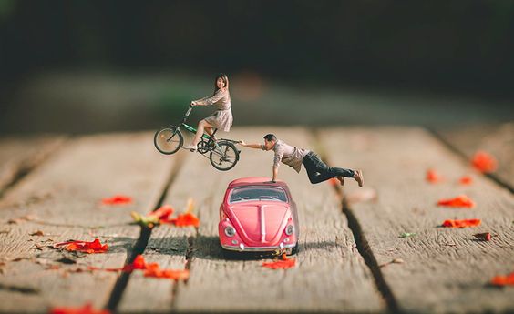pareja diminuta sobre coche rosa