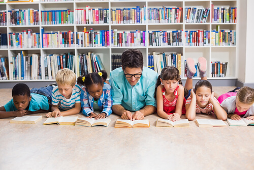 Profesor con sus alumnos leyendo