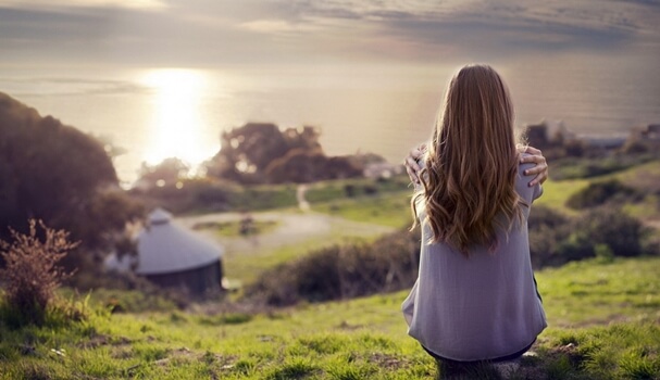 Chica de espaldas pensando en la paradoja de la felicidad