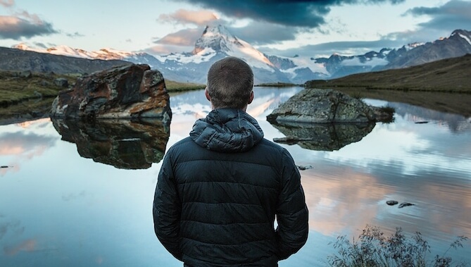 Chico ante un lago pensando en cómo ser emocionalmente más fuertes