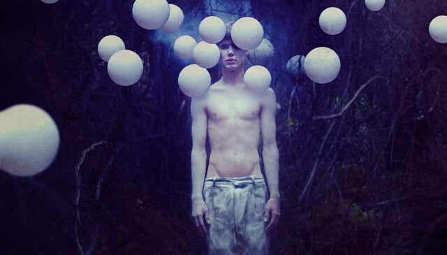 chico rodeado de globos blancos que expresa las emociones