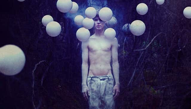 chico rodeado de globos blancos que representan el peso de la tristeza