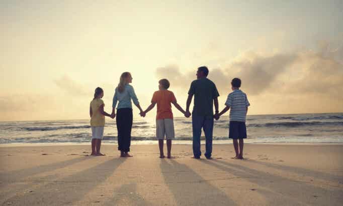 Familia cogida de la mano en la playa