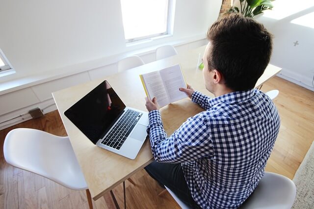 Hombre leyendo en lugar de trabajar