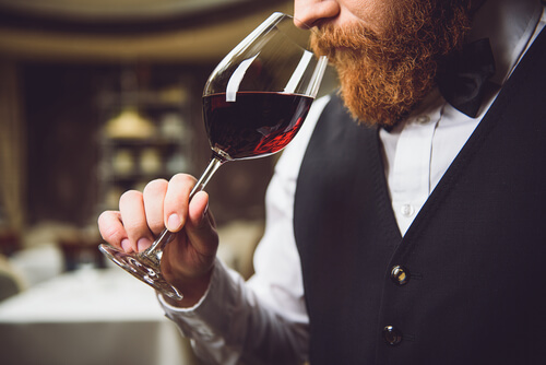 Hombre oliendo vino