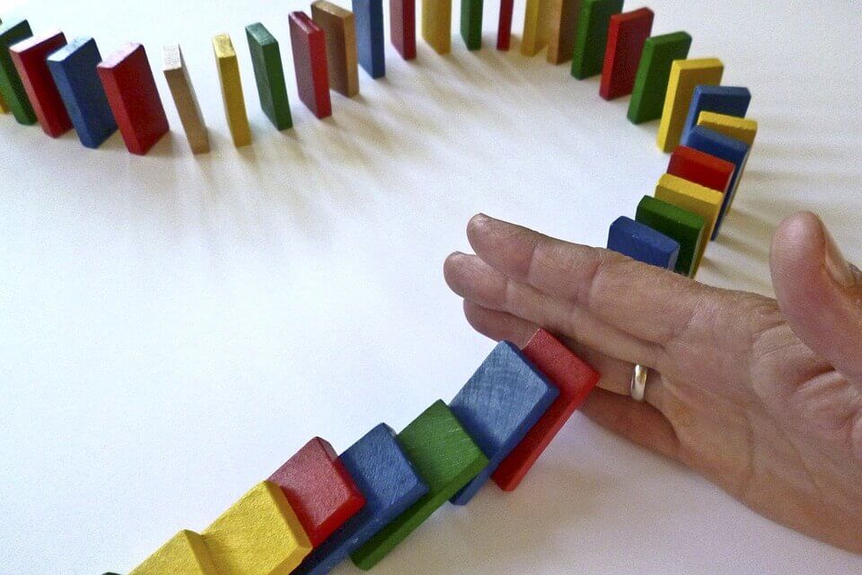 Hand die het domino-effect afsnijdt