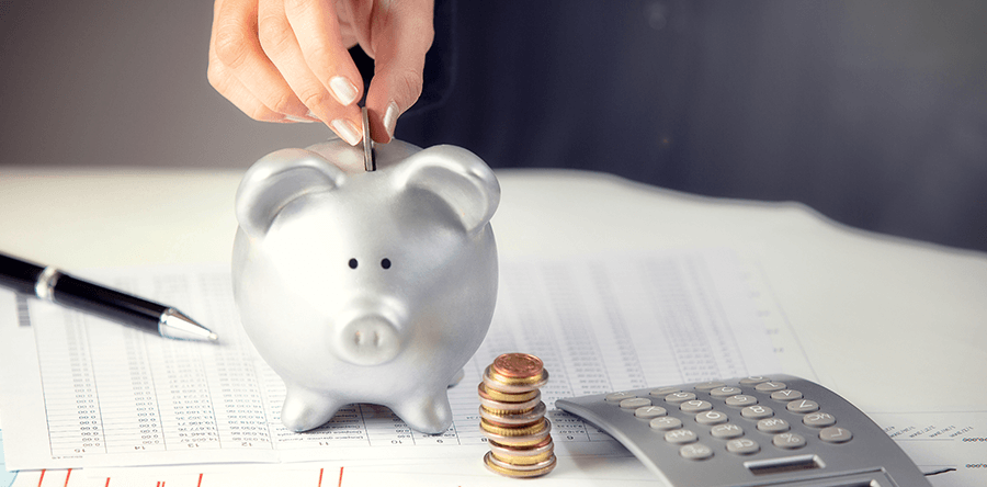 mano metiendo dinero en cerdito para mejorar la situación económica