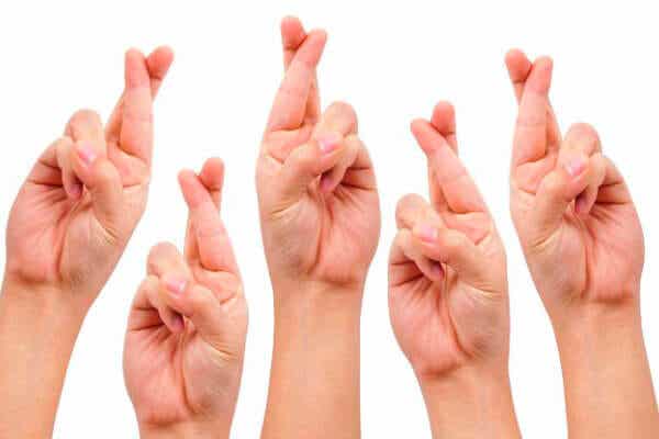 Manos con los dedos cruzados para representar la superstición