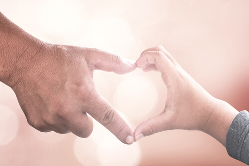 Manos de un niño y de su padre formando un corazón