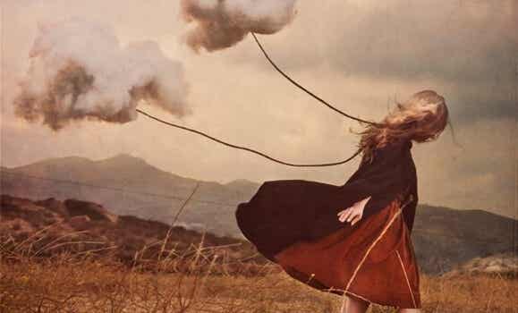 Mujer avanzando con dos nubes sufriendo la ausencia de un ser querido