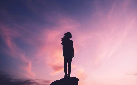 mujer sobre una roca demostrando que la actitud es la fuerza más poderosa