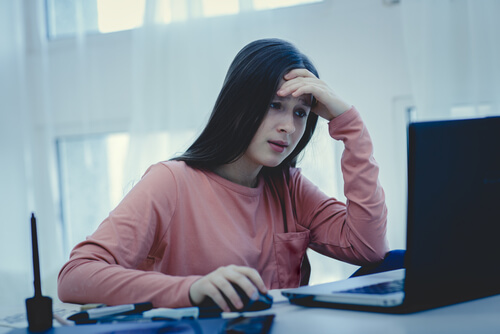 Niña mirando el ordenador siendo víctima de ciberbullying