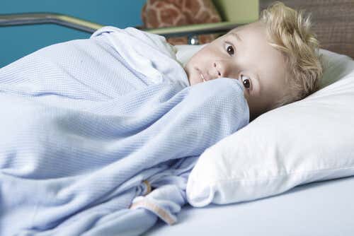 Niño con cáncer en la cama del hospital