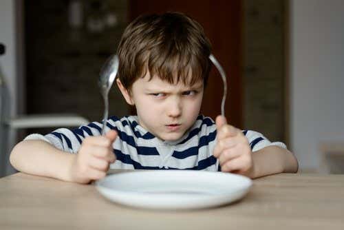 Niño con síndrome del emperador enfadado porque no quiere comer