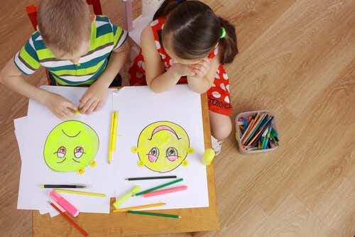 Niños dibujando caras de emociones por la alfabetización emocional