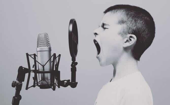 niño elevando tono de voz mientras habla ante microfono