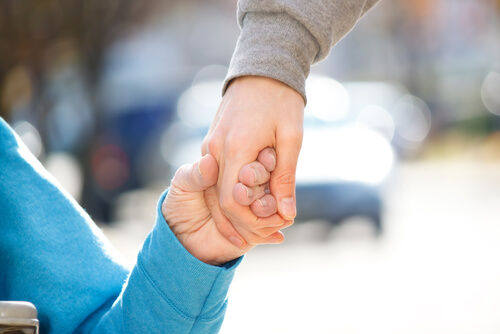 Persona con discapacidad dando la mano a otra como ejemplo de diversidad funcional