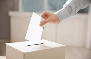 Persona metiendo su voto en una urna