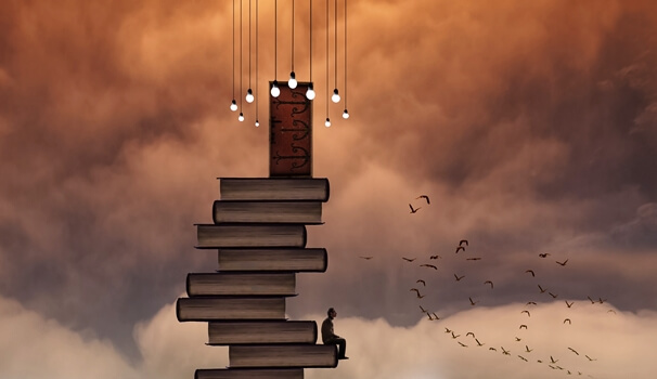 torre de libros con hombre sentado que busca desarrollar el poder la lectura y empatía