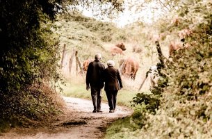 Abuelos andando por un camino agarrados